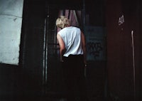 a man standing in front of a door with graffiti on it