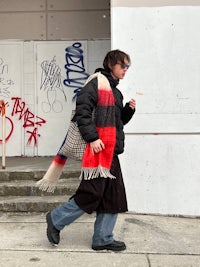 a woman walking down the street with a scarf