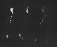 a black and white photo of a group of people standing in the dark