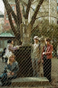 a group of people standing next to a chain link fence