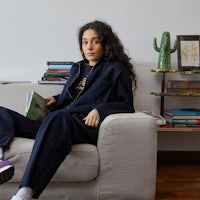 a woman sitting on a couch reading a book