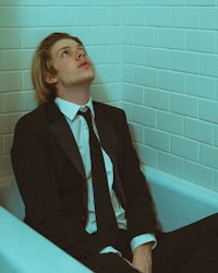 a man in a suit sitting in a bathtub