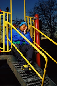 a man is sitting on the steps of a playground