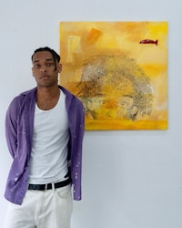 a young man standing in front of a painting