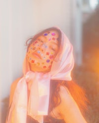 a woman wearing a pink scarf with hearts on her face