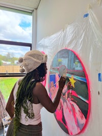 a woman paints a painting in an art studio