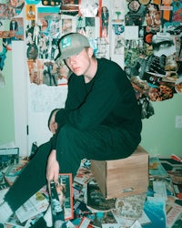 a man sitting on a box in a room full of magazines