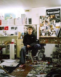 a man sitting on a chair in a messy room