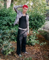 a man with red hair standing in a park