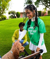 a woman petting a dog in a park