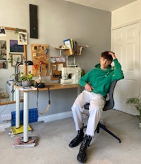 a man sitting on a chair in a green hoodie