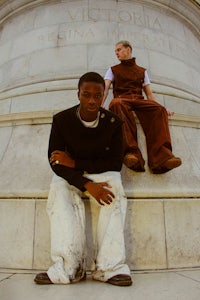 two men sitting on the steps of a monument