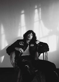 a black and white photo of a man sitting in a chair