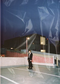 a man standing on a skateboard in a parking lot