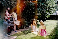 a group of people sitting on the grass