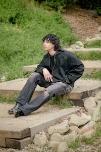 a young man sitting on a set of steps