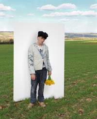 a man standing in a field with flowers