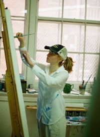 a woman painting on an easel