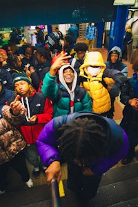 a group of people standing in a subway station