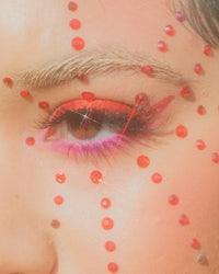 a close up of a woman's eye with rhinestones on it