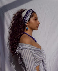 a woman wearing a striped top and blue headband