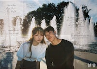 a young couple posing in front of a fountain