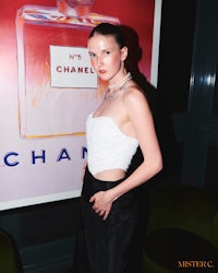 a woman posing in front of a chanel poster