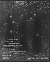 a black and white photo of a group of people standing in the woods