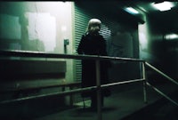 a woman standing on a railing at night