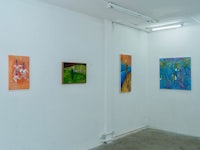 a room with several paintings hanging on the wall