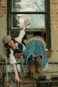 a woman is laying on a chair in front of a window